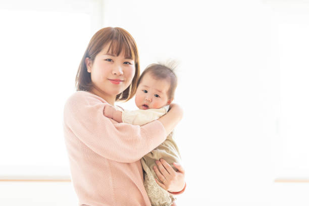 istock Mom holding a baby in a bright room 1215718807