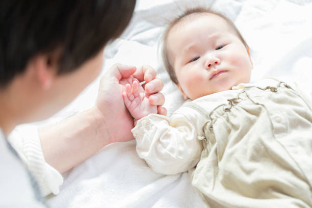 istock Dad comforting baby in bright room 1215718813