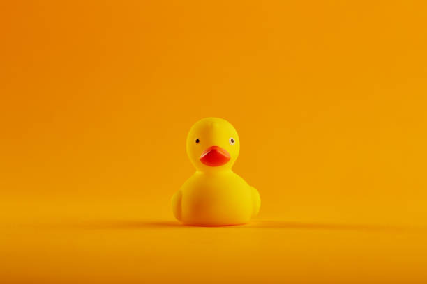 istock Yellow rubber duck toy on orange / yellow background 1215719133