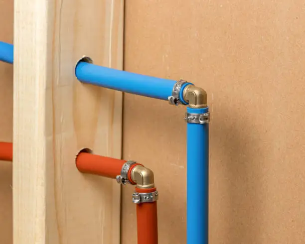 Photo of Pex plastic water supply plumbing pipe in wall of house. Concept of home repair, maintenance and remodeling