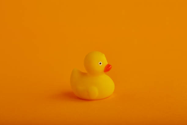 istock Yellow rubber duck toy on orange / yellow background 1215719278