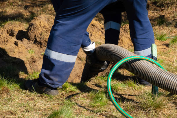 ouvrier d’homme retenant le tuyau, fournissant le service de nettoyage d’égout extérieur. la machine de pompage des eaux usées débloque un trou d’homme bloqué - matière nocive photos et images de collection