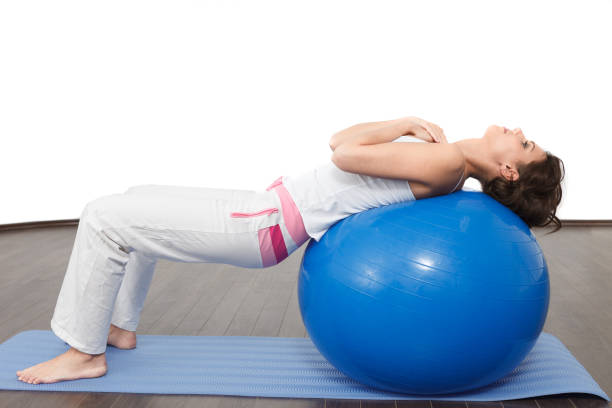 istock Stretching training Woman practicing on a fitness ball 1215723205