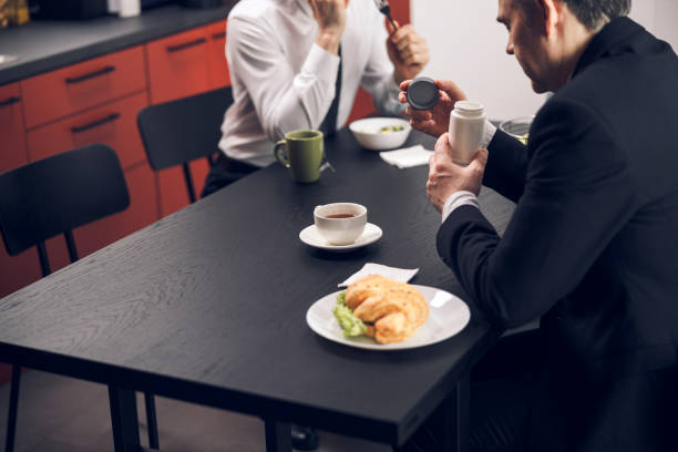 istock Caucasian young men drinking tasty beverage during lunchtime 1215724182