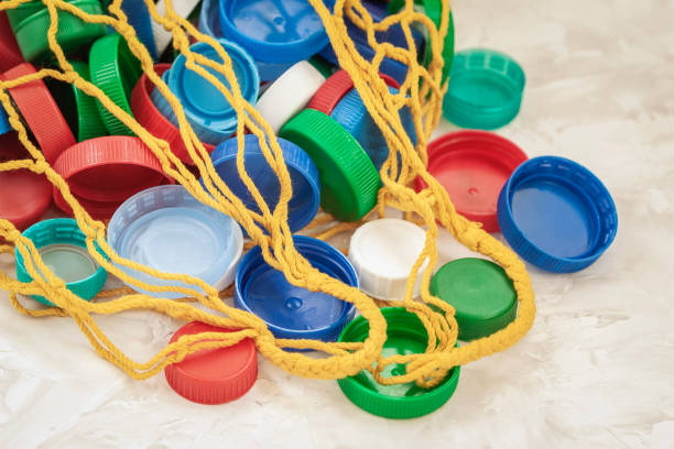 istock Colorful PET plastic bottle caps in mesh string bag stored for recycling, top view. Concept of recycling, ecology, environmental pollution 1215725919