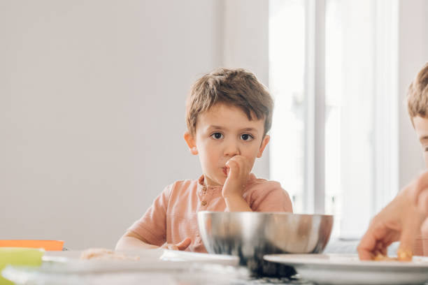 istock Little boys cooking breaded chicken 1215726549