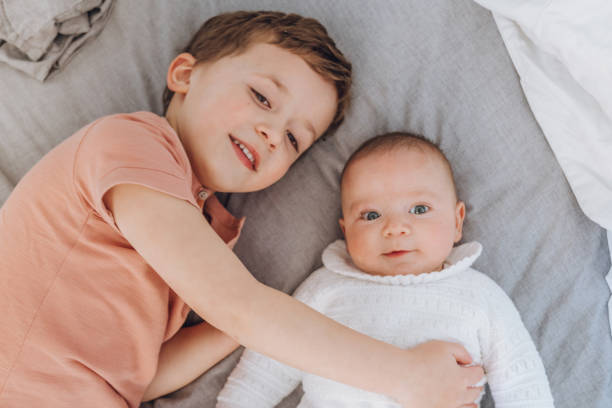 istock Brothers playing with baby on the bed 1215726563