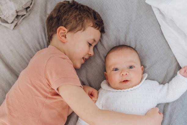 istock Brothers playing with baby on the bed 1215726571