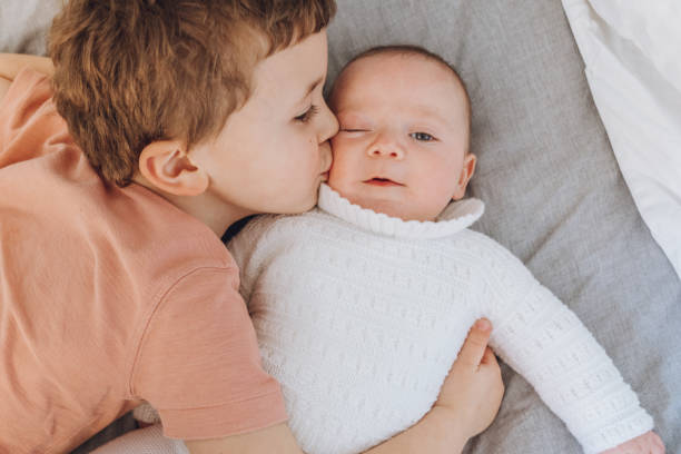 istock Brothers playing with baby on the bed 1215726940