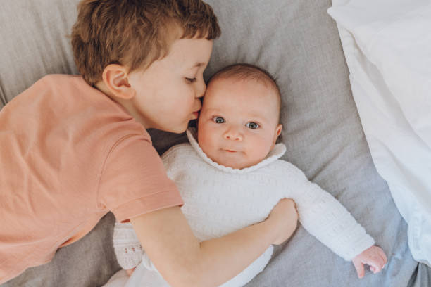 istock Brothers playing with baby on the bed 1215727808