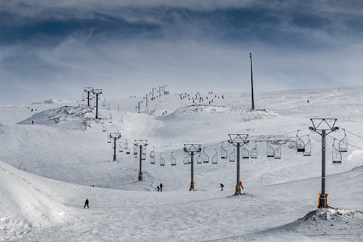 The famous snowed mountain of Parnassos with popular ski resort covered up in snow and unique nature, cable cabins, car parking, Voiotia, Greece