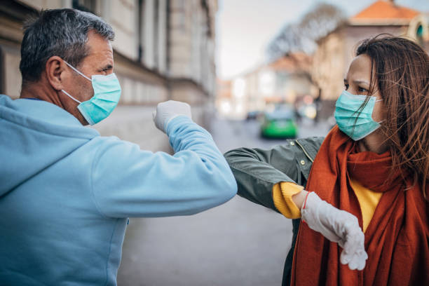 istock Two people greeting each other with elbows instead of handshake 1215729786