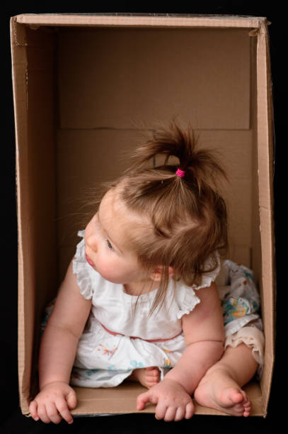 istock Little cute, beautiful girl sits in a box. 1215730389