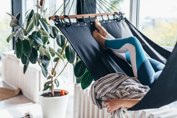 istock Woman is lying at home in a hammock and resting 1215730623