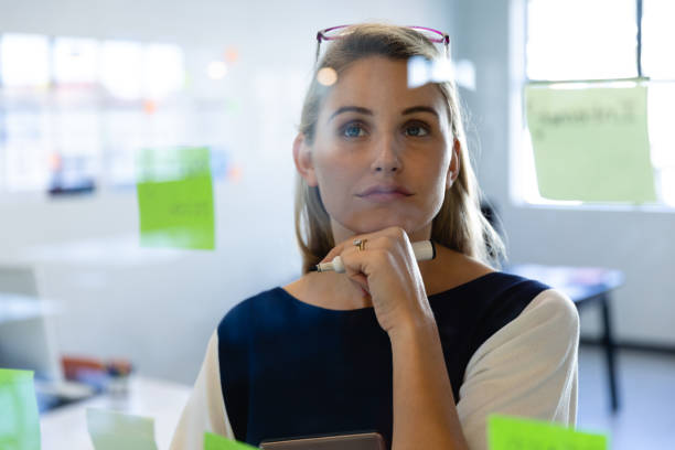 istock Caucasian woman writing on a sticky note 1215732144