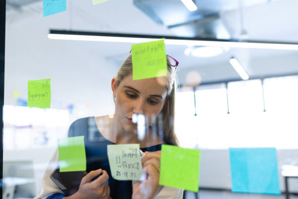 istock Caucasian woman writing on a sticky note 1215732172