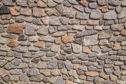 Rough background from old granite boulders. Strong masonry stone fence