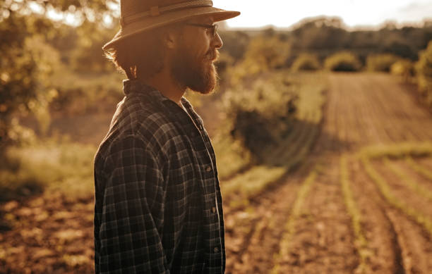 istock Bearded farmer standing near plowed field 1215733664