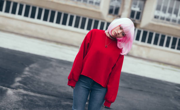 Portrait of a young woman with tattoos and pink hair photographed in London