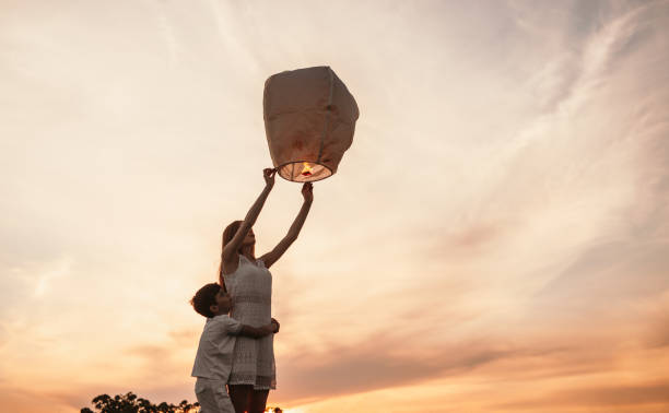 空のランタンを解放する弟とティーンの女の子 - child balloon outdoors little boys ストックフォトと画像