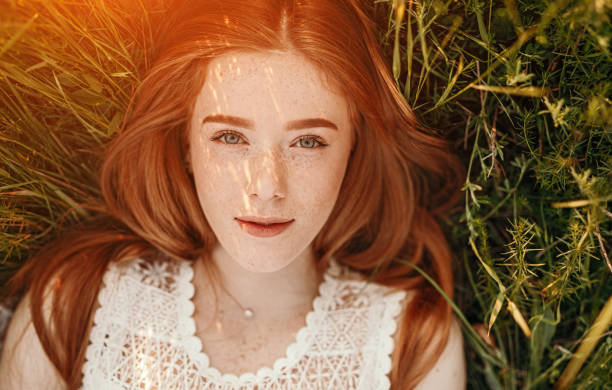 istock Positive ginger girl lying on grass 1215733765