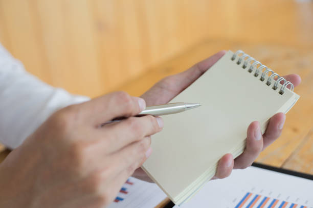 istock Note, male employee taking notes on meeting report on note paper, taking reminders 1215734128