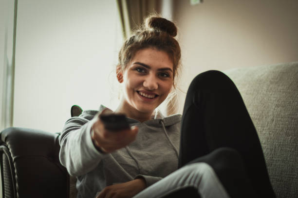 istock Smiling woman watching tv 1215734159
