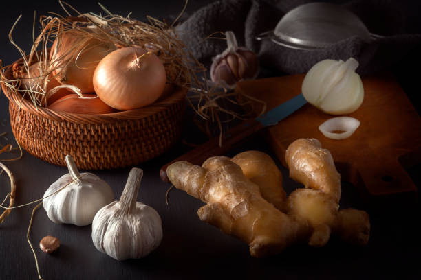 istock Ginger, garlic, onion - a vegetable mixture to increase immunity from viruses on a dark table. Low key. 1215734193