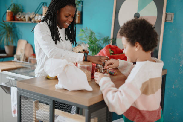 istock Mother and daughter unpacking groceries at kitchen 1215736418