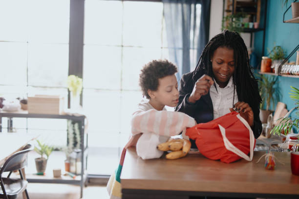 istock Mother and daughter unpacking groceries at kitchen 1215736572