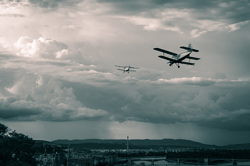 Old Antonov AN-2 biplanes flying in the stormy sky of Budapest, Hungary. The Antonov AN-2 first flight was in 1947