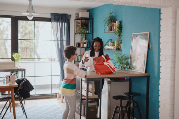 istock Mother and daughter unpacking groceries at kitchen 1215737320