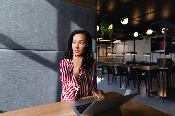 African American woman using her laptop and thoughful