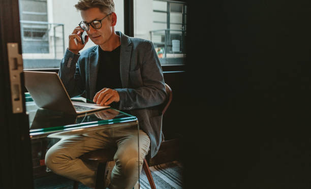 istock Entrepreneur discussing work over mobile phone at his desk 1215738514