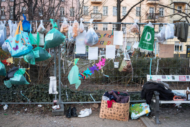 Donation fence, where people can leave food and clothes donations while keeping social distance during COVID-19 crisis Berlin, Germany - March 25, 2020: Fence where people can leave bags with food and other donations for people in need during lockdown. Located on the Boxhagener Platz in Friedrichshain, Berlin.This concept was introduced so people can make donations while keeping the physical distance due to Coronavirus. friedrichshain photos stock pictures, royalty-free photos & images