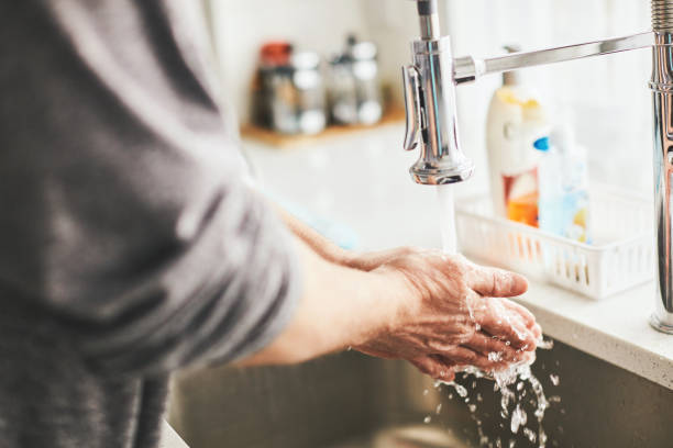 istock Man washing his hands under kitchen faucet 1215739380