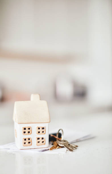 Little home on kitchen counter with keys and paperwork Little home on kitchen counter. New home or mortgage concept modern cottage interior design stock pictures, royalty-free photos & images