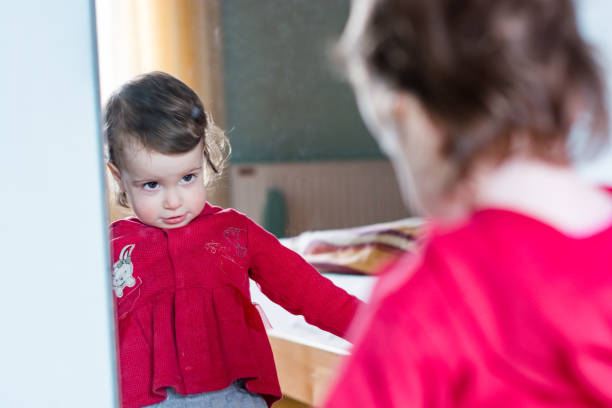 istock Little girl with reflection in a mirror 1215741734