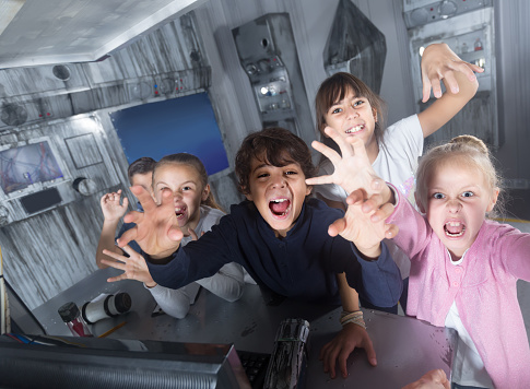 Enthusiastic children play in the quest room of a inscrutable bunker