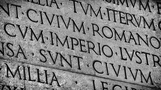Latin ancient language and classical education. Inscription from Emperor Augustus famous Res Gestae (1st century AD), with the word Imperio in the center