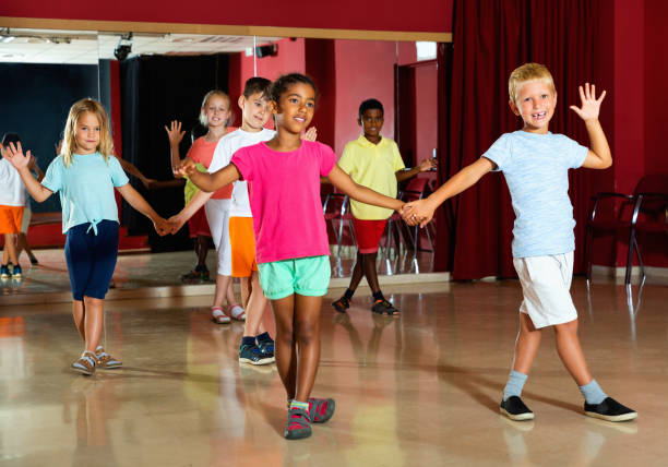 istock Smiling children primary school trying dancing salsa dance in modern studio 1215746829