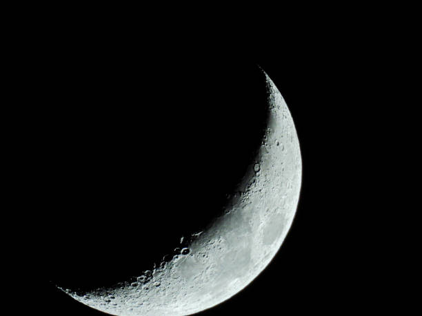 istock increasing sickle-shaped quarter moon with its moon craters stands in the black night sky 1215747114