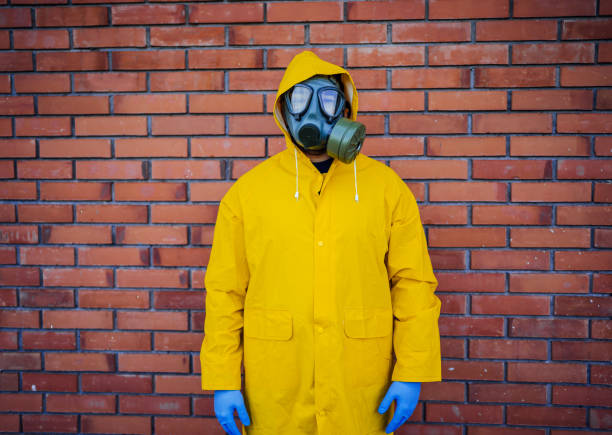 istock Man in a protective suit and gas mask in front of a wall 1215748103