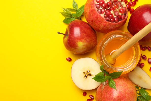 istock Apple, honey and pomegranate on yellow background, top view 1215748104