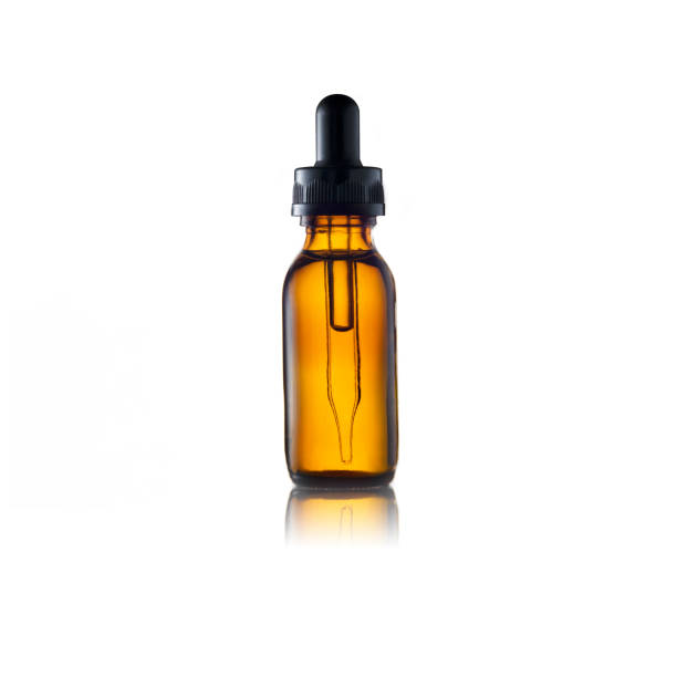 suero o aceite esencial en botella de vidrio marrón sobre fondo blanco - pipeta fotografías e imágenes de stock