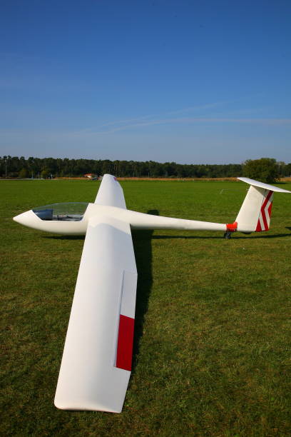 istock Glider at green airfield with blue sky 1215748726