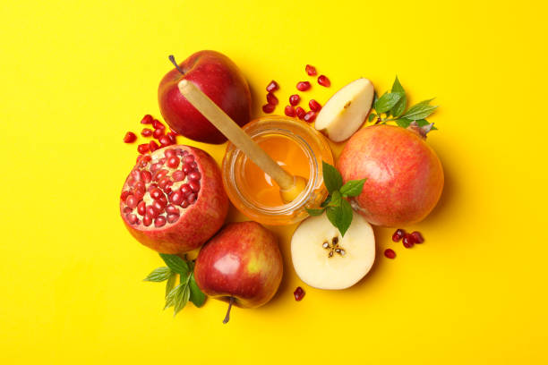 istock Apple, honey and pomegranate on yellow background, top view 1215749802