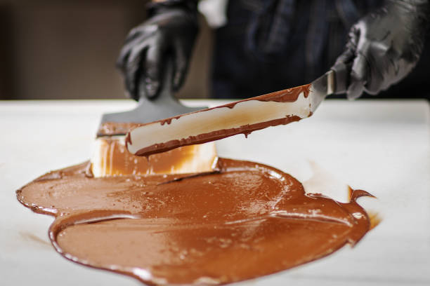 istock Confectioner in gloves makes chocolates in forms 1215750088
