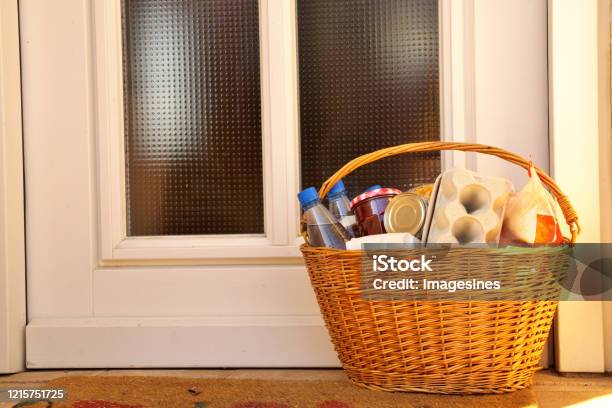 Delivery During The Quarantine Full Willow Wicker Basket With Merchandise Goods And Food In Front Of The Door Neighborhood Assistance Concept At Quarantine Time Of Coronavirus Infection Covid19 Stock Photo - Download Image Now