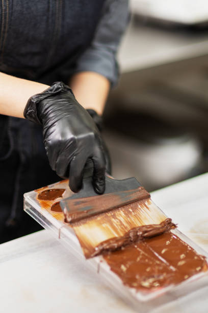 istock Confectioner in gloves makes chocolates in forms 1215753474